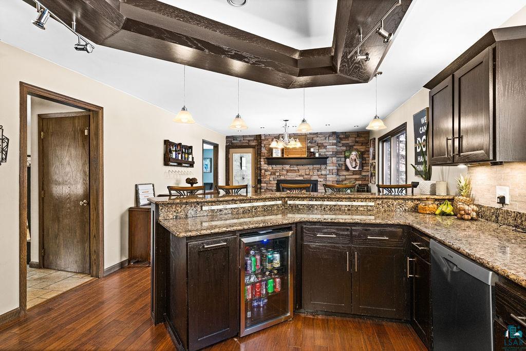 421 St Louis River Road Proctor, MN 55810 - Photo 26 of 57 Bar featuring dark wood finish cabinets, wine cooler, decorative light fixtures, and stainless steel dishwasher
