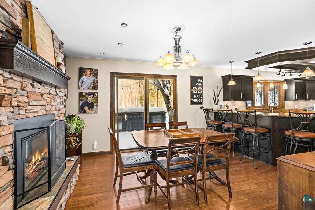 421 St Louis River Road Proctor, MN 55810 - Photo 28 of 57 Dining space featuring a fireplace, dark wood-type flooring, and suspended lighting