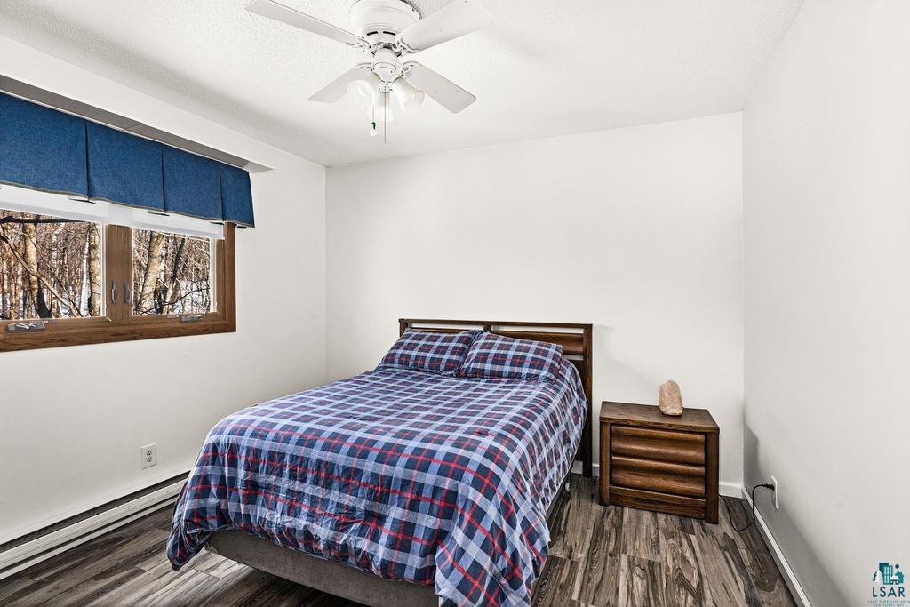 421 St Louis River Road Proctor, MN 55810 - Photo 38 of 57 Bedroom featuring baseboard heating, dark wood-style flooring, and a ceiling fan