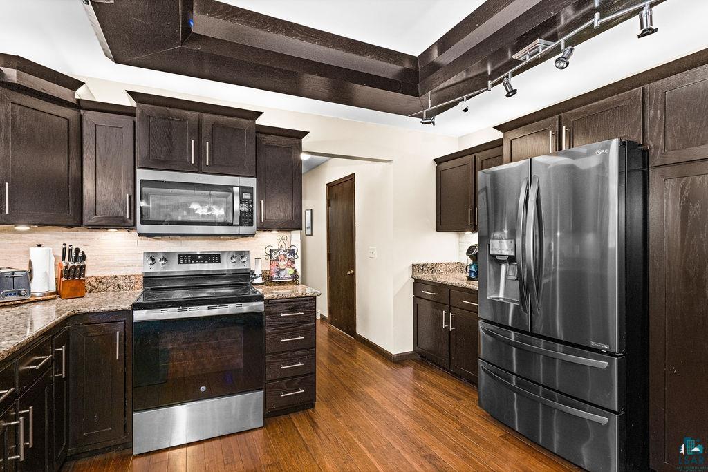 421 St Louis River Road Proctor, MN 55810 - Photo 4 of 57 Kitchen featuring dark wood finish cabinetry, stainless steel appliances, light stone countertops, and dark wood-type flooring