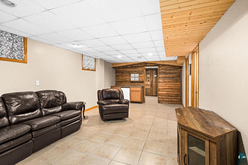 421 St Louis River Road Proctor, MN 55810 - Photo 42 of 57 Living room with log walls, a drop ceiling, and light tile patterned floors