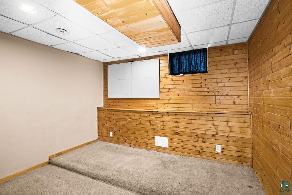 421 St Louis River Road Proctor, MN 55810 - Photo 49 of 57 Carpeted spare room featuring a drop ceiling and wooden walls