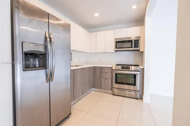 a kitchen with stainless steel appliances a refrigerator and a stove top oven