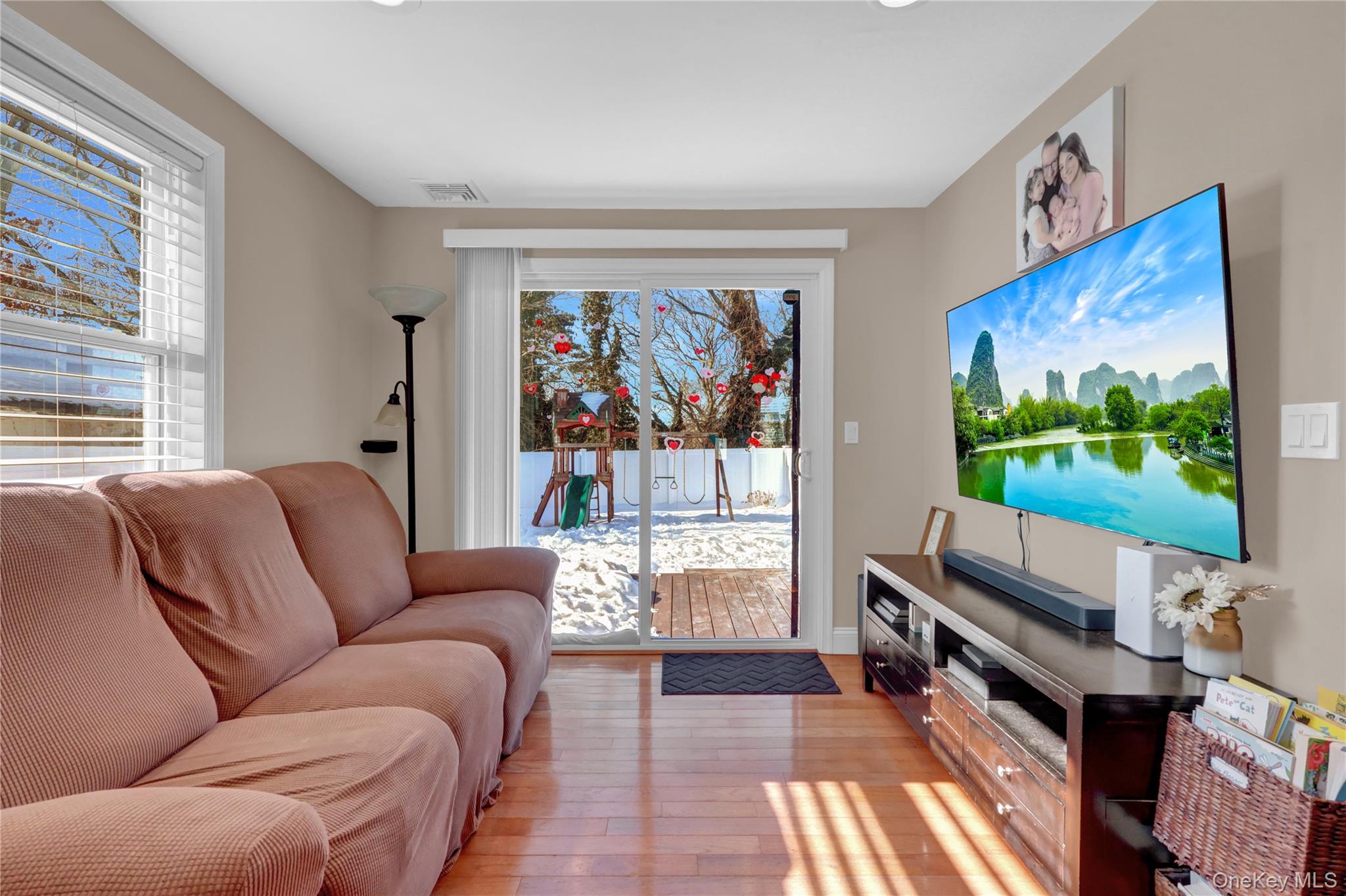 522 Browns Road Nesconset, NY 11767 - Photo 14 of 29 a living room with furniture a flat screen tv and a floor to ceiling window