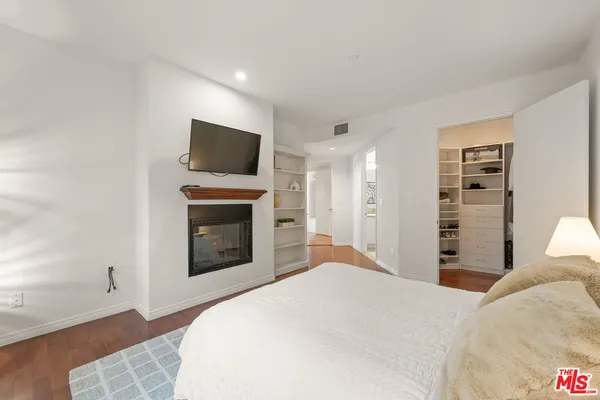 a bedroom with a bed and a lamp on dresser