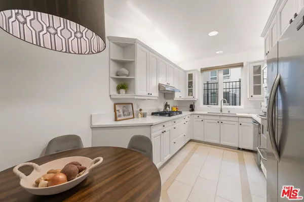 a kitchen with stainless steel appliances granite countertop a sink dishwasher stove and refrigerator with wooden floor