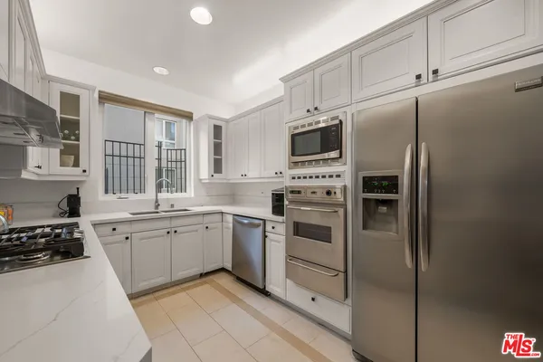 a kitchen with cabinets stainless steel appliances and a window
