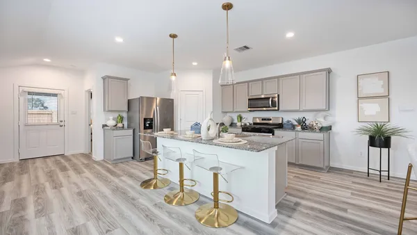 a kitchen with stainless steel appliances granite countertop a refrigerator a stove top oven a sink dishwasher and white cabinets with wooden floor