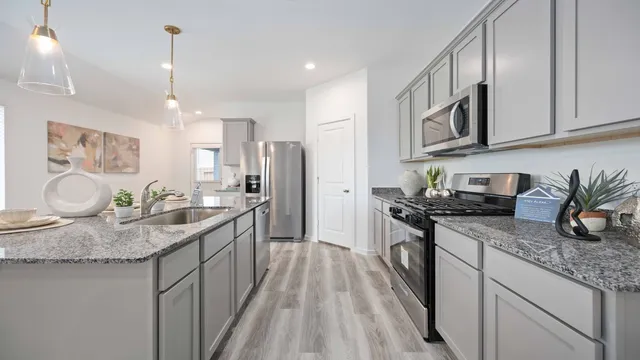 a kitchen with stainless steel appliances granite countertop a sink stove and refrigerator