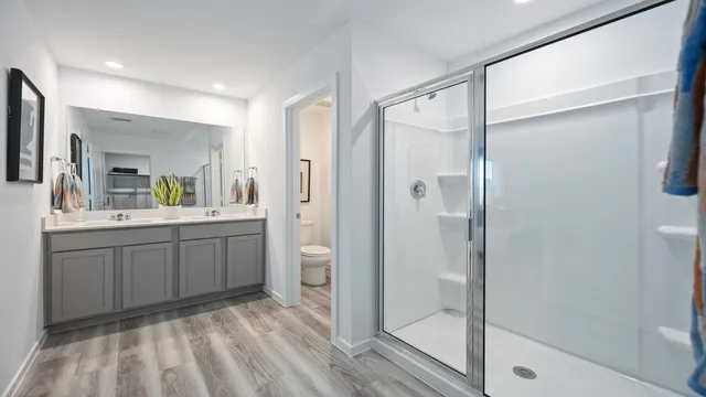 a spacious bathroom with a shower sink and mirror
