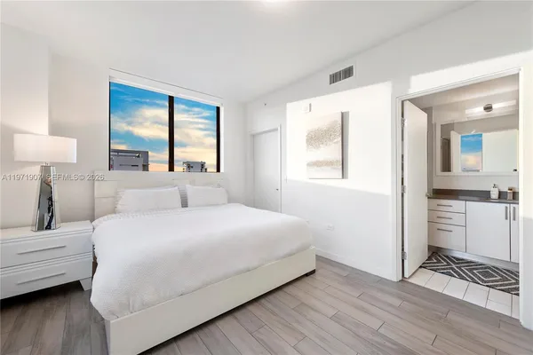 a bedroom with a bed and a large window