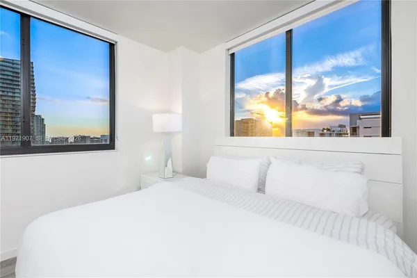 a bedroom with a large window and a bed