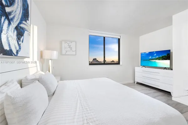 a bedroom with a bed and a flat screen tv