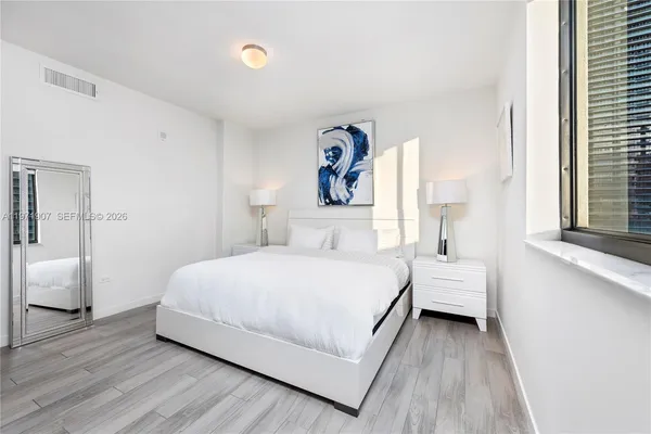 a bedroom with a bed and a large mirror