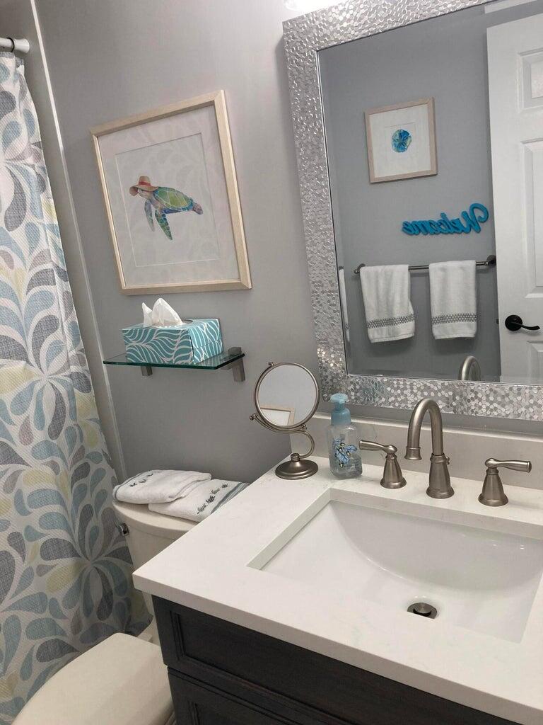 166 Southeast St Lucie Boulevard, Unit D404 Stuart, FL 34996 - Photo 11 of 14 a bathroom with a toilet sink and mirror