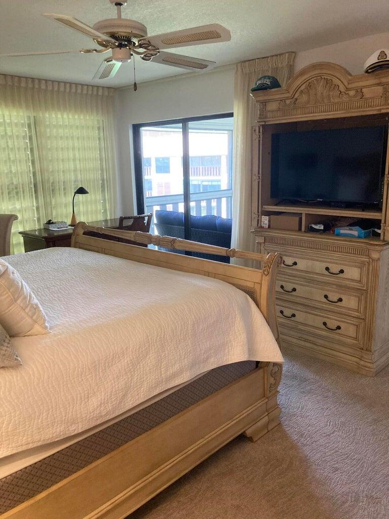 166 Southeast St Lucie Boulevard, Unit D404 Stuart, FL 34996 - Photo 8 of 14 a spacious bedroom with a bed and large flat screen tv