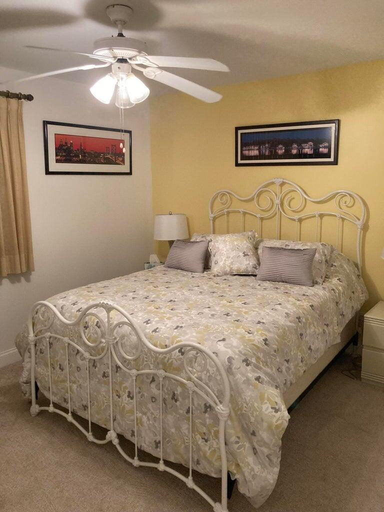166 Southeast St Lucie Boulevard, Unit D404 Stuart, FL 34996 - Photo 10 of 14 a bedroom with a bed and a chandelier