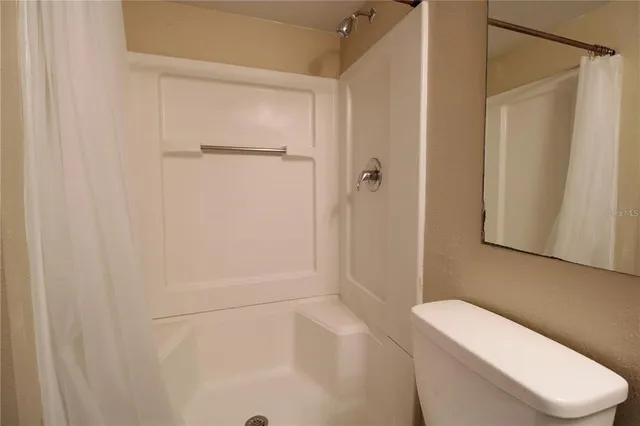 a white toilet sitting next to a bathroom sink