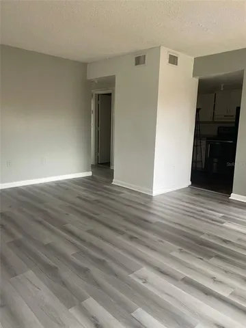 a view of an empty room with wooden floor