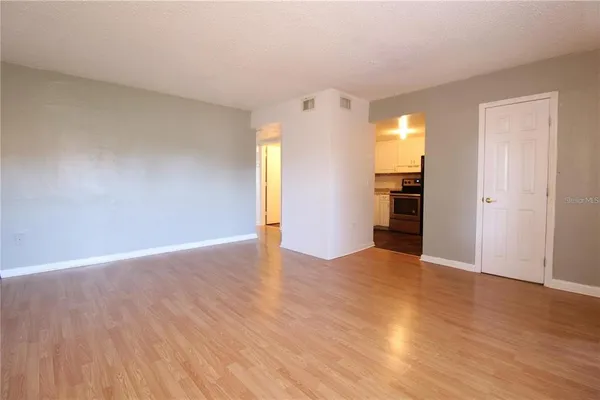 a view of empty room with wooden floor