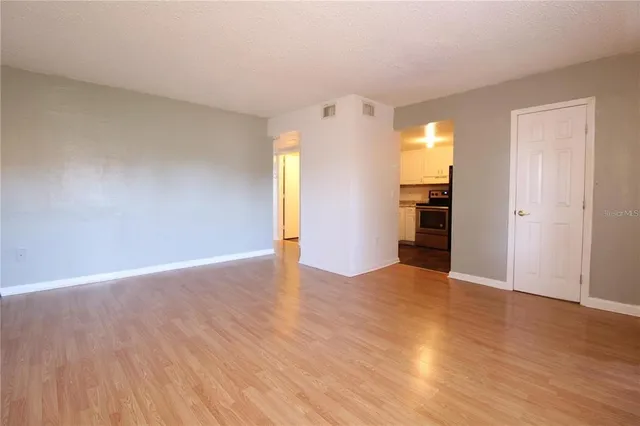 a view of empty room with wooden floor