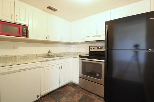 a kitchen with cabinets and stainless steel appliances