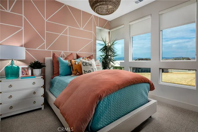 a bedroom with bed and a lamp on dresser