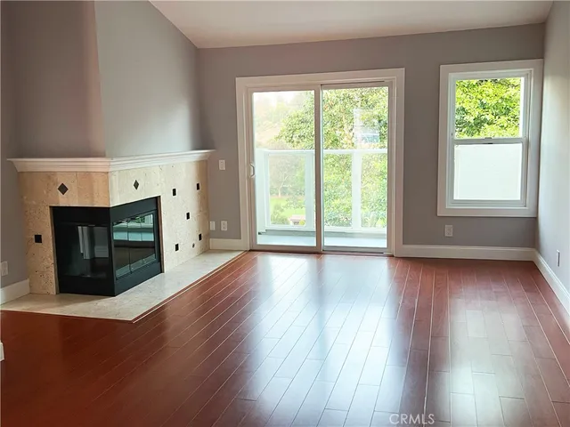 a view of empty room with wooden floor and fireplace