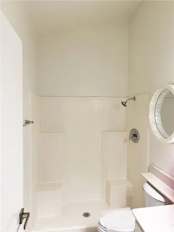 a bathroom with a toilet and a shower