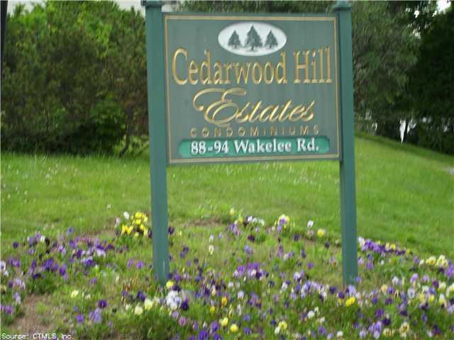 92 Wakelee Road, Unit 6 Waterbury, CT 06705 - Photo 1 of 1 a sign that is sitting in front of flowers