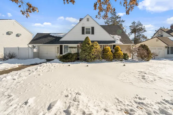 a front view of a house with a yard covered in snow