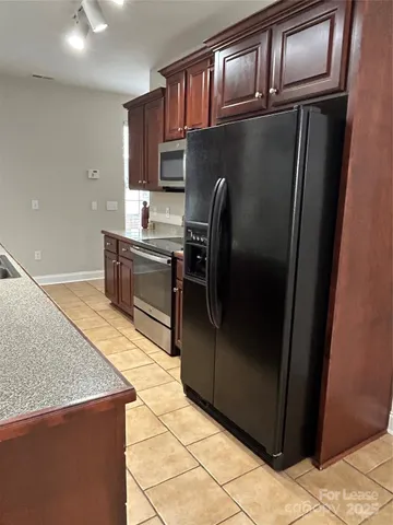 a kitchen with stainless steel appliances granite countertop a refrigerator a sink and dishwasher