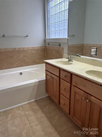 a bathroom with a tub sink and mirror