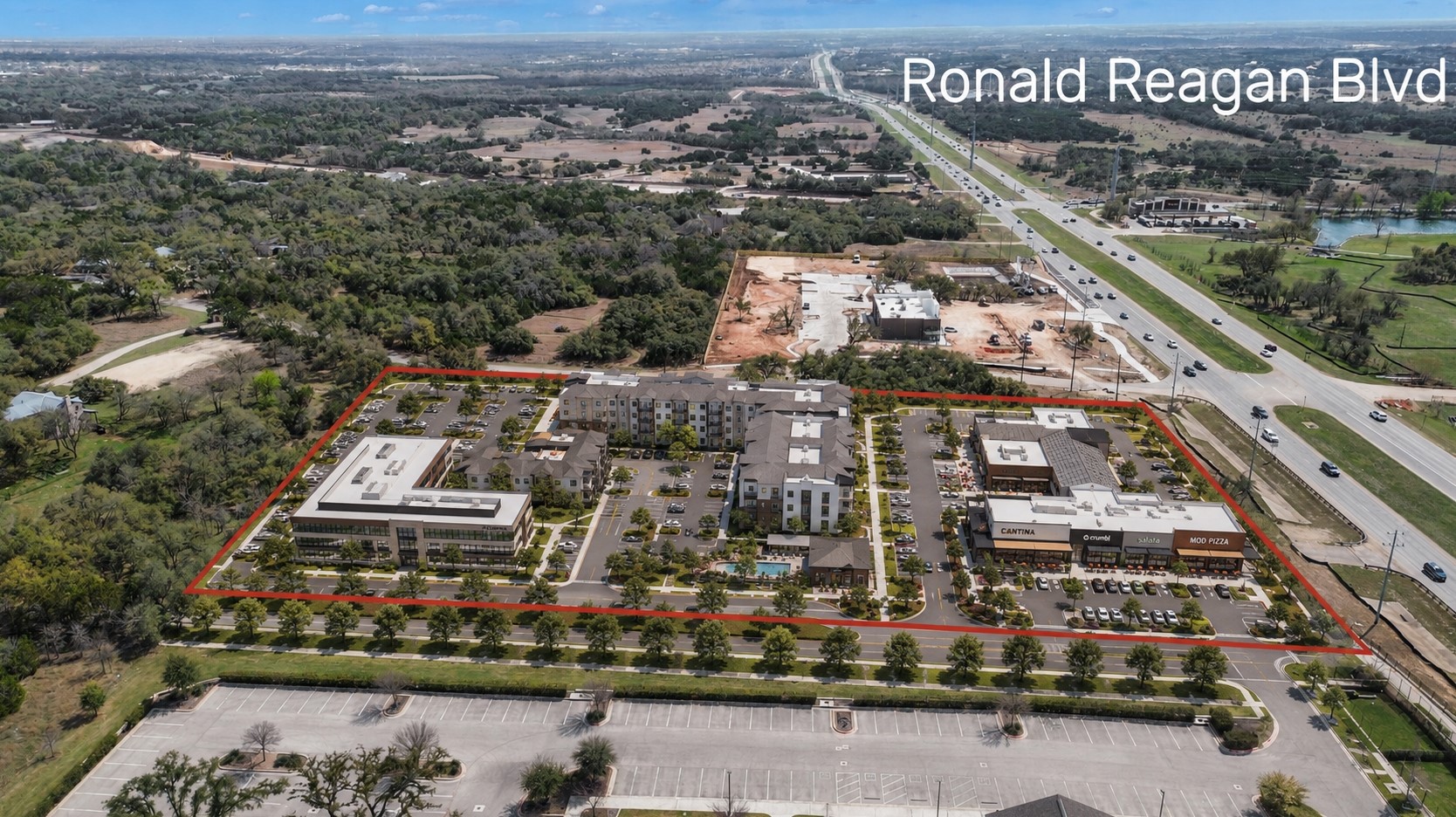 51 County Road 264 Leander, TX 78641 - Photo 1 of 17 An aerial perspective reveals a vibrant mixed-use development, harmoniously integrated with natural green spaces and convenient highway access.