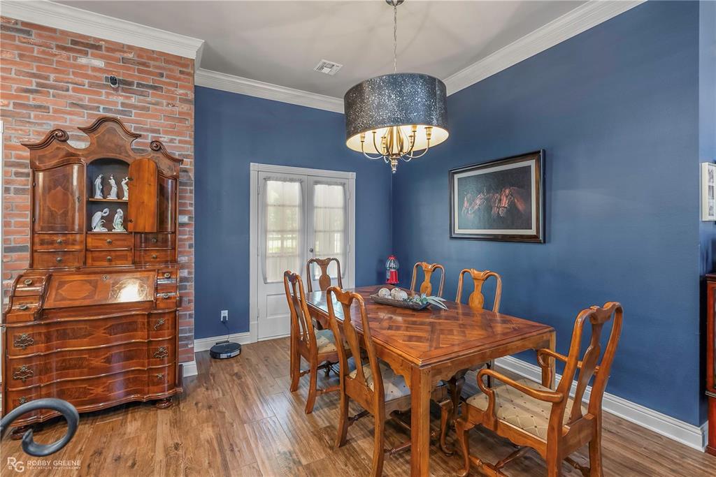 1171 Wemple Road Bossier City, LA 71111 - Photo 11 of 31 Dining room with wood finished floors, french doors, crown molding, and a chandelier