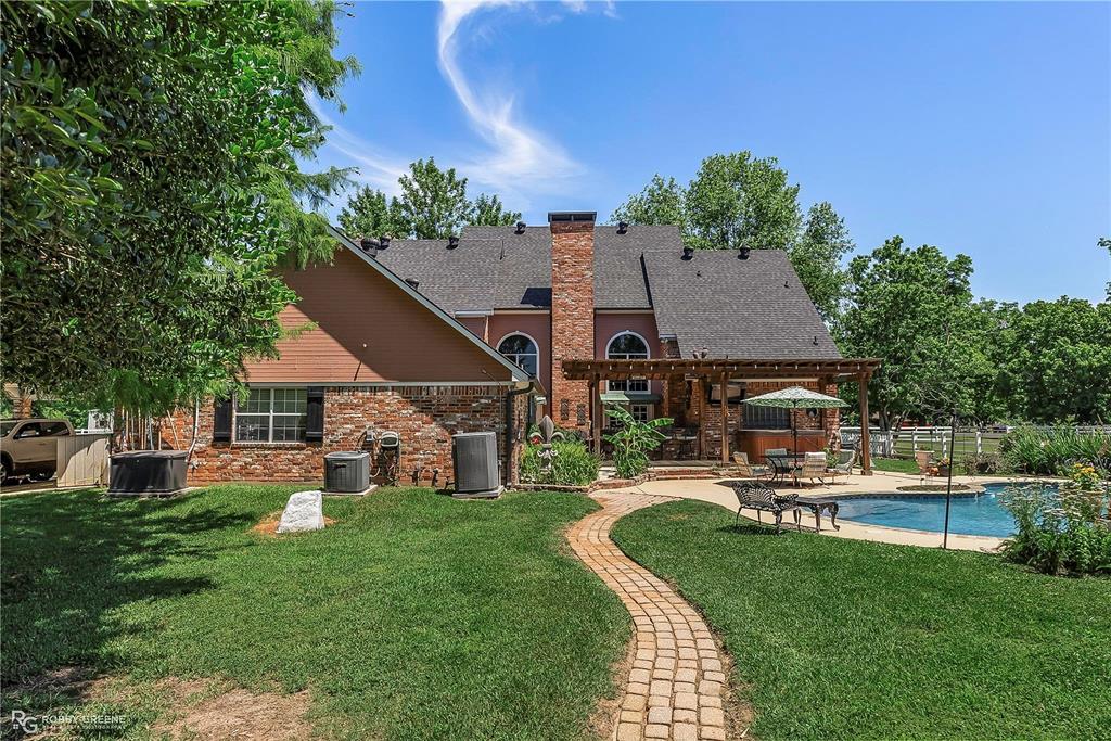 1171 Wemple Road Bossier City, LA 71111 - Photo 23 of 31 Rear view of house with a pergola, a patio, a chimney, brick siding, and roof with shingles