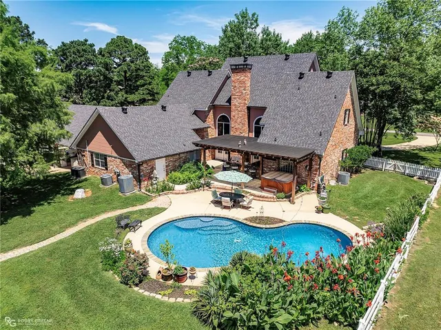 an aerial view of a house with swimming pool garden and patio