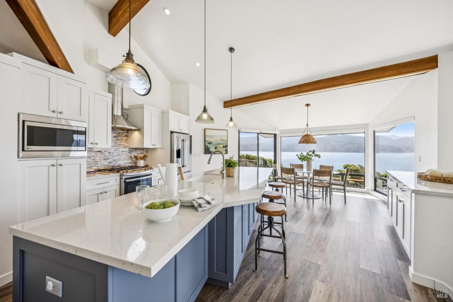 17523 Highway 1 Marshall, CA 94940 - Photo 9 of 72 a kitchen with stainless steel appliances a table chairs and a wooden floor