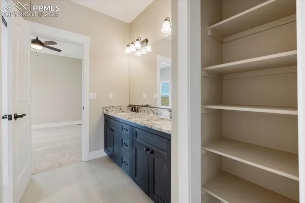 a bathroom with a granite countertop sink two mirror and a shower