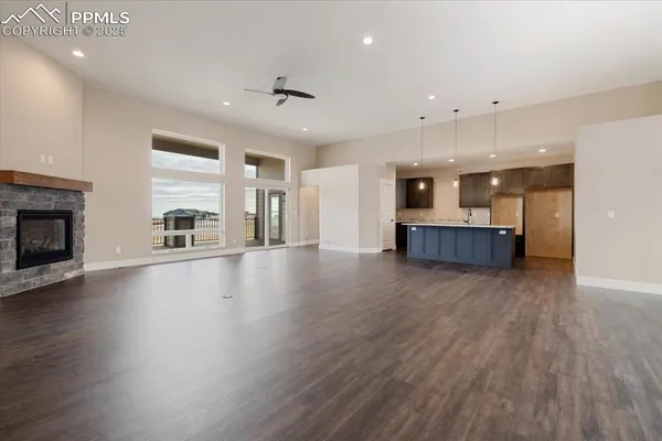 an empty room with kitchen and fireplace