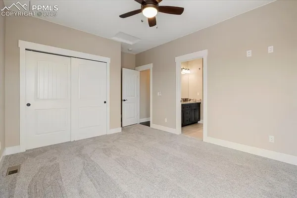 an empty room with ceiling fan and window