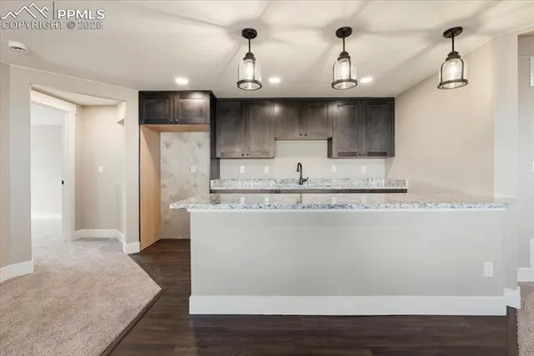 a view of a kitchen with stainless steel appliances granite countertop a sink and a refrigerator