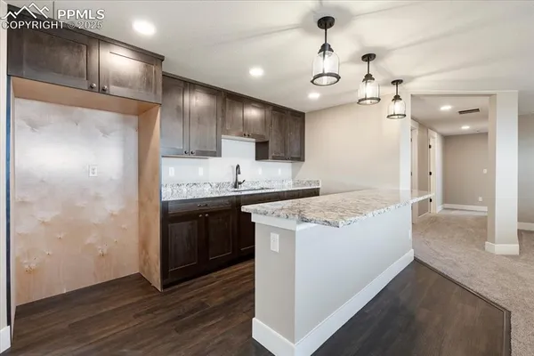 a kitchen with kitchen island a sink stainless steel appliances and cabinets