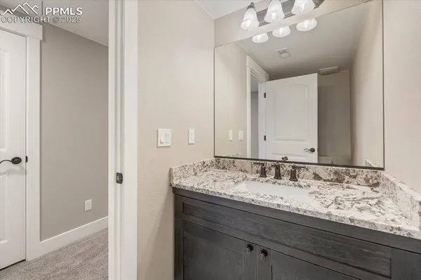 a bathroom with a granite countertop sink a large mirror and vanity