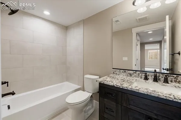 a bathroom with a granite countertop sink a toilet and bathtub