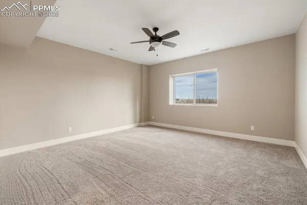 an empty room with a window and a ceiling fan