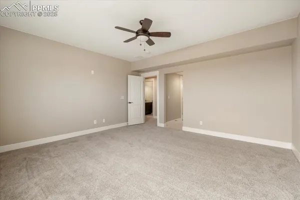 a view of an empty room with a ceiling fan