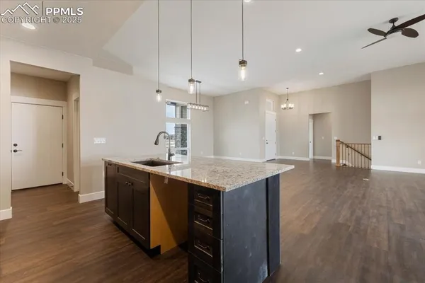 a kitchen with a sink a counter space and wooden floor