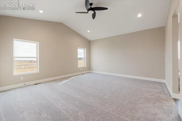 an empty room with windows and ceiling fan