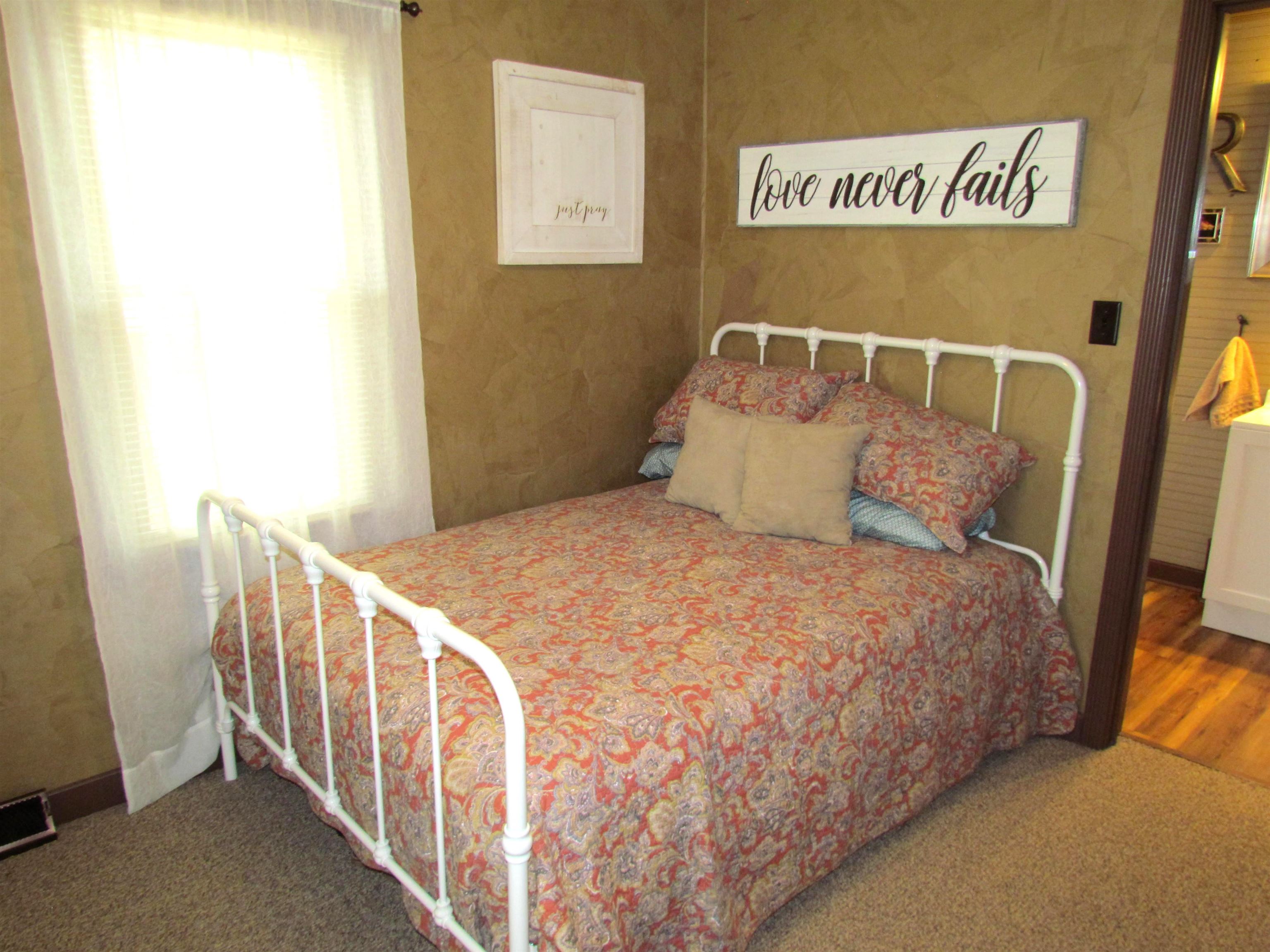 727 Elgin Street Cherry Valley, IL 61016 - Photo 18 of 35 a bedroom with a bed and wooden floor